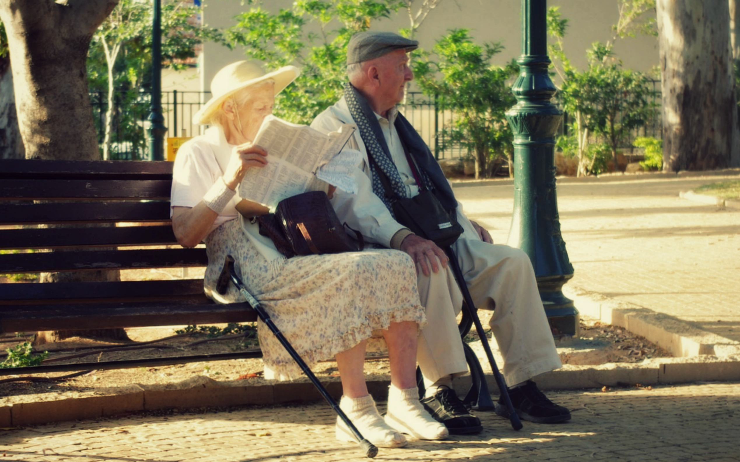 Two elderly people sat on a bench